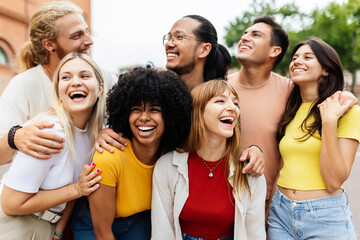 Diverse group of young friends having fun together outside. Millennial student people laughing and having fun enjoying holiday. Youth community and friendship concept.