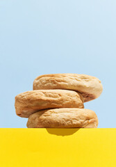 Bolo de caco. Traditional portuguese bread on blue and yellow creative background in minimal style