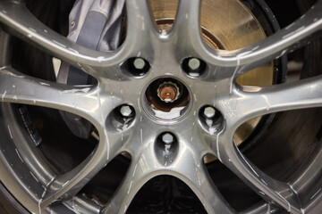 Detailed view of a car wheel rim being cleaned with foam for maintenance and shine