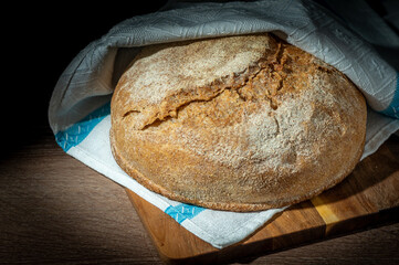 Freshly baked whole grain bread with slices on a wooden table 1