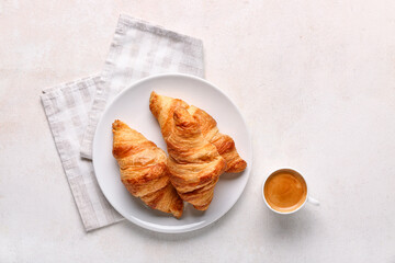 Plate with tasty croissants and cup of coffee on white background