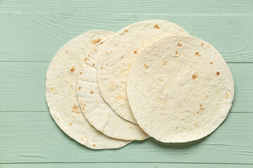 Tasty thin lavash on green wooden background