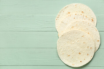 Tasty thin lavash on green wooden background