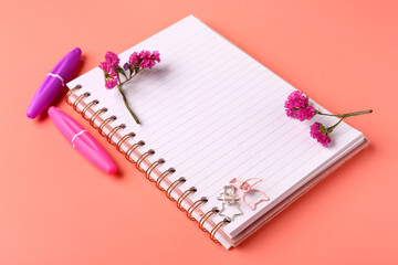Aesthetic flowers, paper clips and notebook on pink background