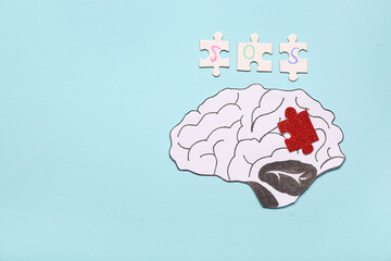 Paper brain with, puzzle pieces and word SOS on blue background. Multiple Sclerosis Awareness Month