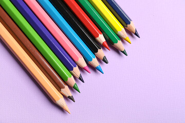 Set of color pencils on purple background, closeup