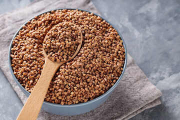 Buckwheat Grains in Wooden Spoon on Gray Background, Close Up