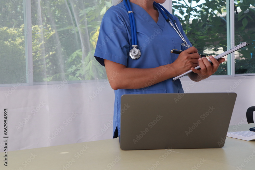 Wall mural a middle-aged asian female doctor and nurse work at a desk, providing medical advice through online 