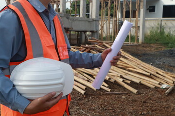 A team of engineers inspects beam work and installs concrete pillars according to the blueprint.