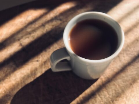 Xícara de Café Quente com Sombra Suave ao Redor, Criando um Efeito Visual Aconchegante e Elegante. Café em Xícara com Iluminação Natural e Sombra Delicada, Ideal para Momentos de Relaxamento. Bebida Q