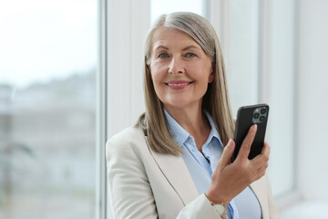 Fototapeta premium Senior woman using mobile phone at home, space for text