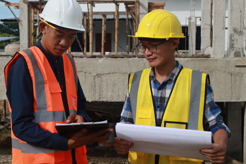 A team of engineers inspects beam work and installs concrete pillars according to the blueprint.