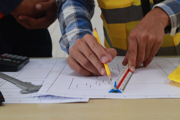 A team of engineers inspects beam work and installs concrete pillars according to the blueprint.