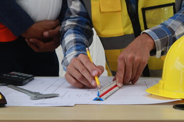 A team of engineers inspects beam work and installs concrete pillars according to the blueprint.