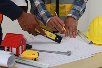 A team of engineers inspects beam work and installs concrete pillars according to the blueprint.