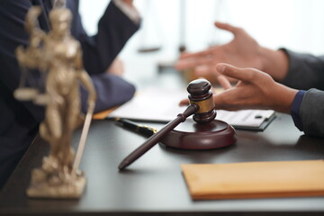 Judge hammer with lawyer A judge holds a team meeting at a law firm, solicitor, partner or barrister to discuss contract terms. Close-up pictures