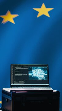 Vertical video AI technology used by European Union alliance to combat illegal bot accounts on social media. Artificial intelligence algorithms detecting fake news running on laptop in EU command