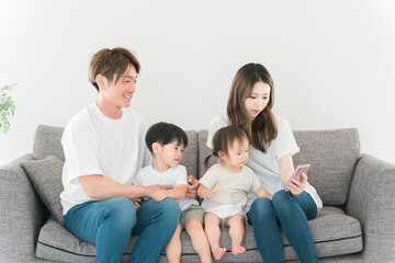 家でスマホ・スマートフォンを見る家族・ファミリー
