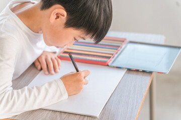 学校・塾の教室で授業を受ける小学校低学年の男の子（ぬりえ・色鉛筆）
