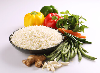 cooked plain white basmati rice served in a  bowl, vegetable in background



