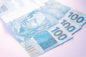 Notas do Real Brasileiro em fundo branco. Fotografia com ângulo fechado. Economia do Brasil. Notas de 100 reais.