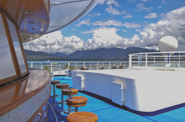 Deck chairs and sun loungers on outdoor swimmingpool pool deck with panoramic ocean views on modern luxury Italian cruiseship cruise ship liner