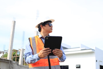 Young professional engineer in hat and blueprint paper is working...At the house construction site. Motivation: success, career growth. achieving goals