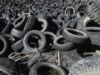 Production of regenerated rubber for tires. A landfill with old tires for recycling. A pile of black old car tires. Environmental pollution. Environmental problems. Recycling of rubber tires.