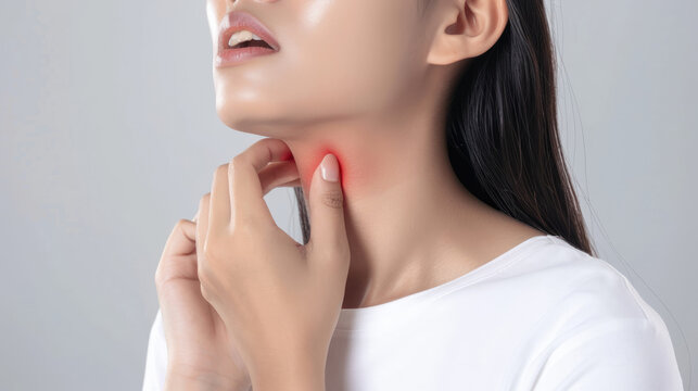 Close up of a woman with her hand on her neck, indicates discomfort and pain in the throat, red aura in touch