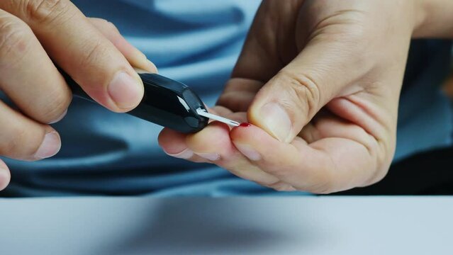 hand of man check diabetes and high blood glucose monitor with digital pressure gauge. Healthcare and Medical concept	