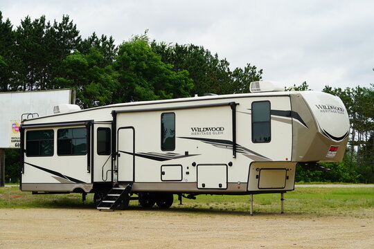 5th wheel campers sit to be sold in a parking lot.