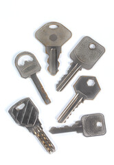 A set of house door keys made of metal isolated on a white background