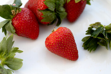 FRESH ORGANIC STRAWBERRIES WITH LEAVES ON WHITE BACKGROUND