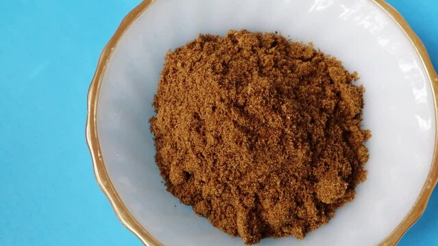 Garam masala or spice powder rotate in a bowl. Top view. Closeup shot&mdash;a mixture of garam masala powder background. 