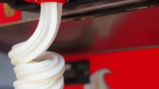 Closeup of Soft Serve Ice Cream Machine Dispensing Vanilla Ice Cream into a Cone
