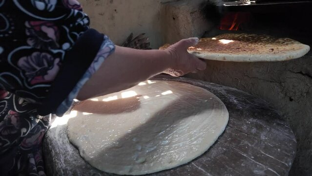 preparing bread in a traditional Dagestan village bakery. Bread is a flatbread baked in a Koryuk oven, common in the cuisine of the North Caucasus.