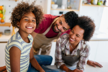 Happy african american family preparing healthy food in kitchen, having fun together on weekend