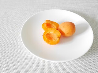 白い皿の上の生食用あんず「ハーコット」（断面）