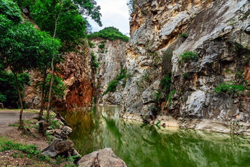 Beautiful nature scenic landscape with mountain range and beautiful hidden spot in Khao Ngu Stone Park at Ratchaburi, Thailand. Landscape view of mountain cliffs In green canyon lake. Amazing nature.