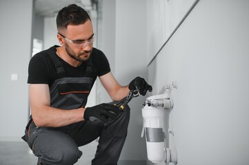 Plumber installs or change water filter. Replacement aqua filter.