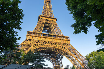 Base structure of Eiffel tower in Paris, France. Early golden morning light