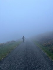 Fototapeta premium Person walking in the mist