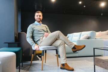 Fototapeta premium Front view of customer choosing chair in furniture store.