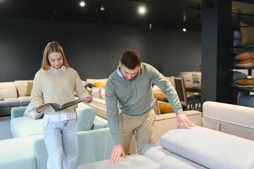 Obraz premium Attractive woman with her husband at the furniture store showroom