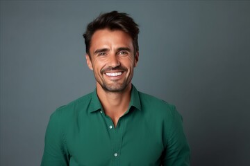 Fototapeta premium Portrait of a handsome smiling man in green shirt on grey background