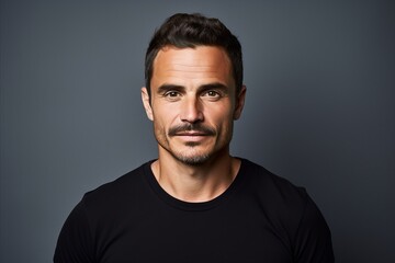 Fototapeta premium Portrait of a handsome man in black t-shirt over grey background.