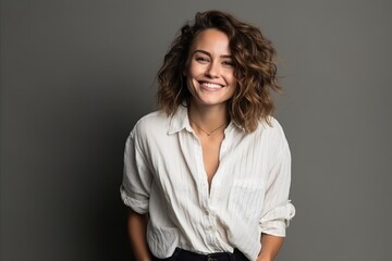 Fototapeta premium Pretty young brunette in a white blouse and black pants smiling
