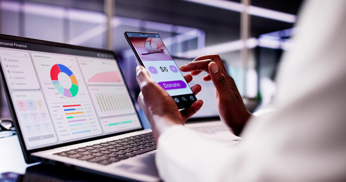 African American woman using smartphone app to donate money online - Powered by Adobe