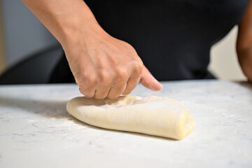 Baker kneading dough on table   