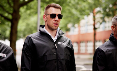 security guard and his group walking on the street, safeguarding buildings
